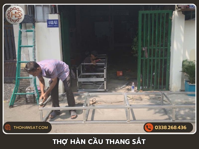 Thợ hàn cầu thang sắt bậc cao đang gia công khung xương thép tại xưởng