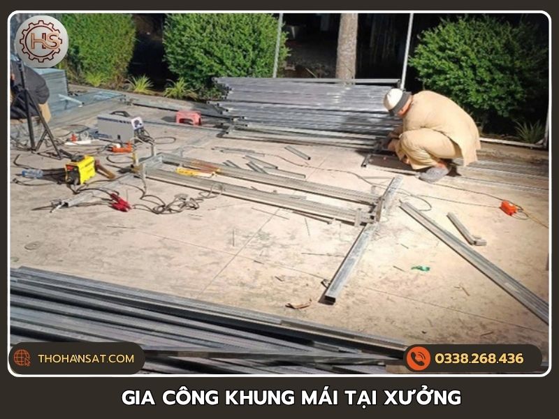 Thợ cơ khí thực hiện cắt hàn gia công khung mái che bằng sắt tại xưởng